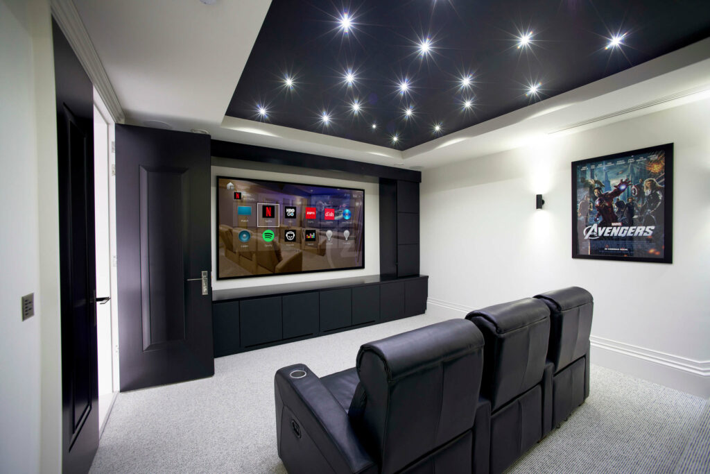 A home theater with smart tv and fancy lights on its ceiling.